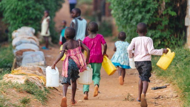 Bambini che corrono con le taniche per l'acqua | Safari Uganda